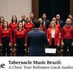 Concert scene featuring a choir and orchestra on a Brazilian stage during a touring program.